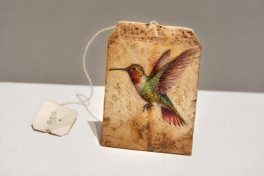 Miniature hummingbird painting on an upcycled teabag